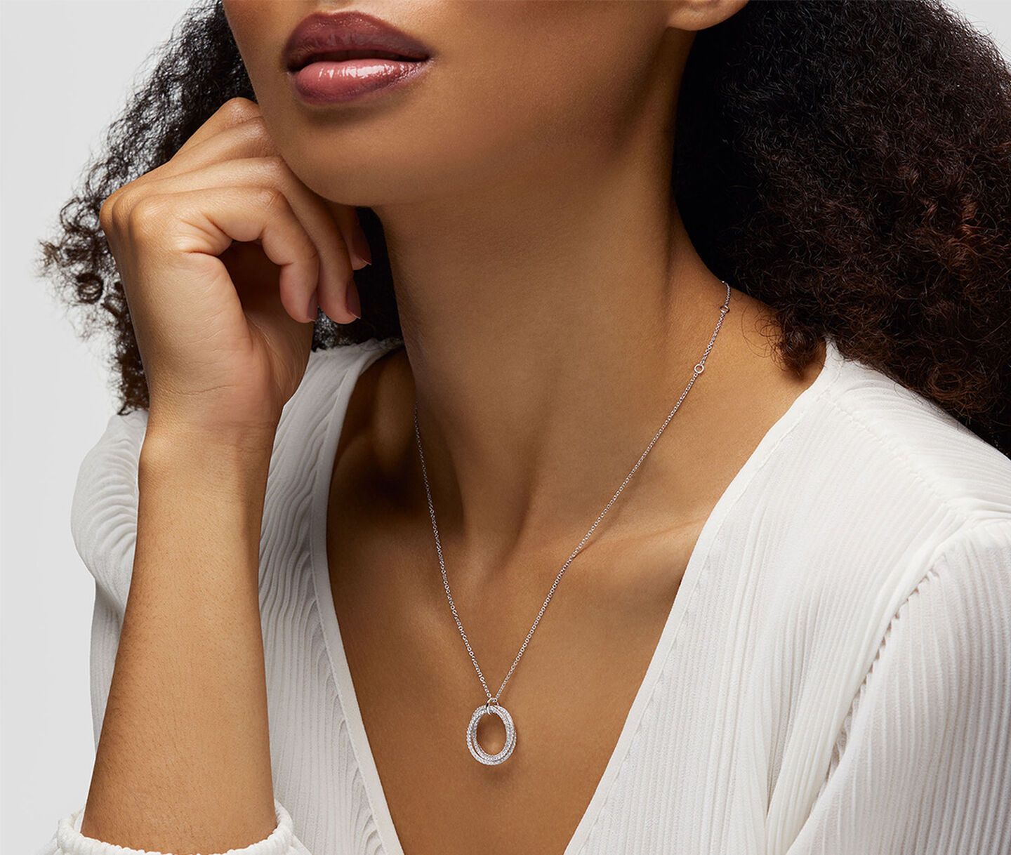 A woman wearing a Birks Rosee du Matin diamond necklace.